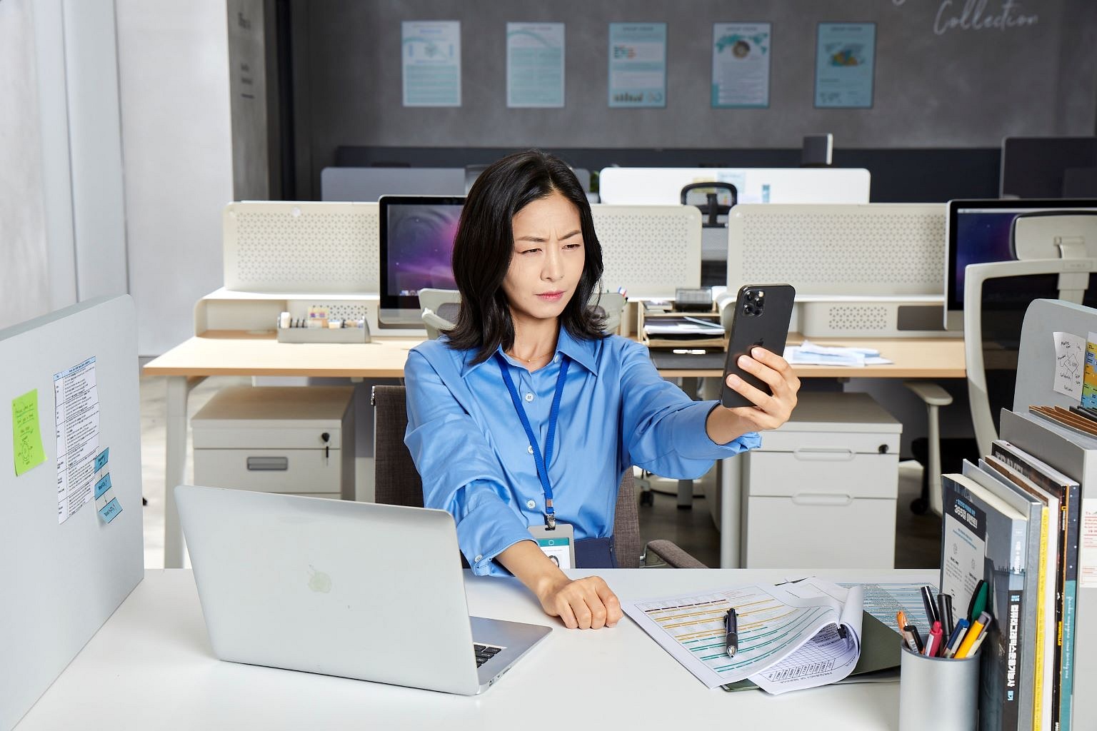 Asian woman with presbyopia sitting at a table and squinting into her phone