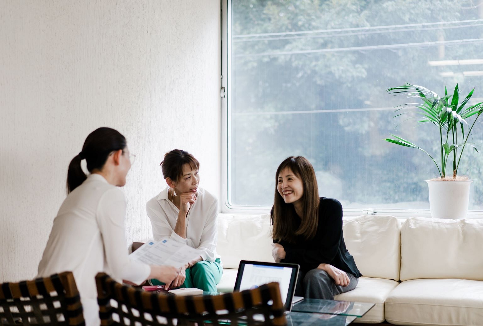 Three Asian women sitting in an office discussing